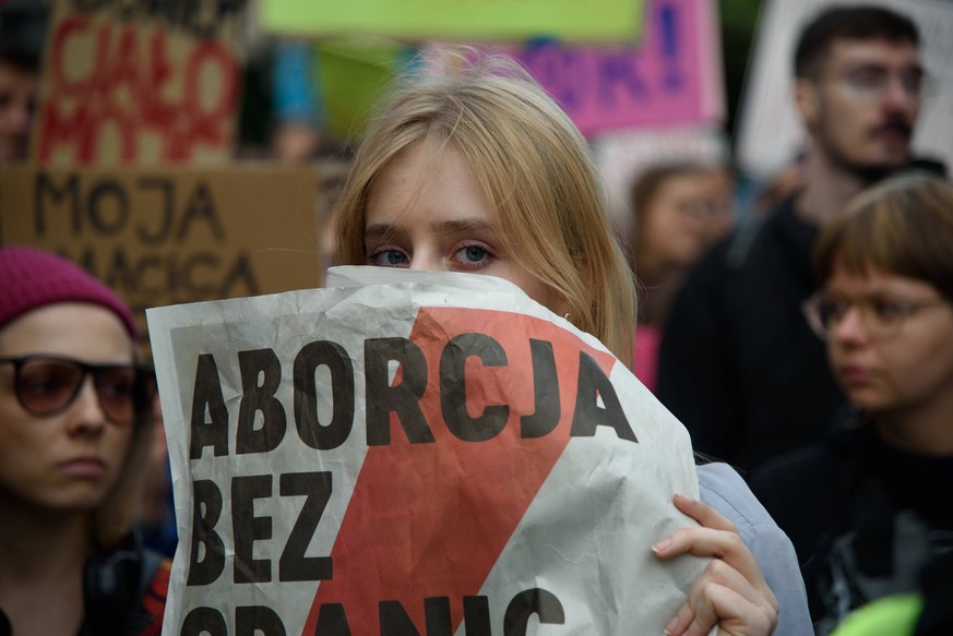 Rally in support of safe abortion access in Warsaw. A woman holds a paper reading Abortion without frontiers as she takes part in a protest in support of legal and safe abortion access in Warsaw, Pola ...