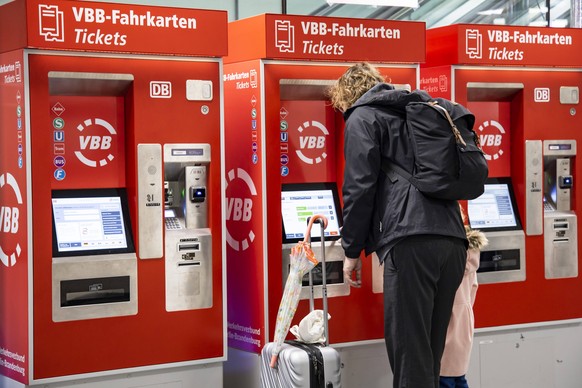 Menschen kaufen Fahrkarten an den Automaten im DB Reisezentrum in Fredrichstrasse in Berlin am 14. April 2023. 49 Euro Ticket kommt *** People buy tickets from vending machines at DB Reisezentrum in F ...