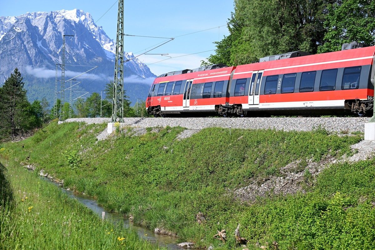 25.05.2023, Bayern, Garmisch-Partenkirchen: Ein Zug fährt an der Zugunglücksstelle vorbei. Am 3.Juni 2022 entgleiste an der Stelle eine Regionalbahn, fünf Menschen starben. (zu dpa: «Ein Jahr nach töd ...