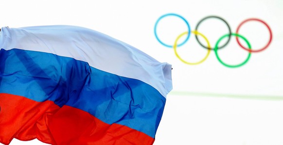 ARCHIV - 09.02.2014, Russland, Sotschi: Ein Athlet aus Russland feiert mit einer Flagge nach einem Event bei den Olympischen Spielen 2014. Das Internationale Olympische Komitee soll nach dem Willen de ...