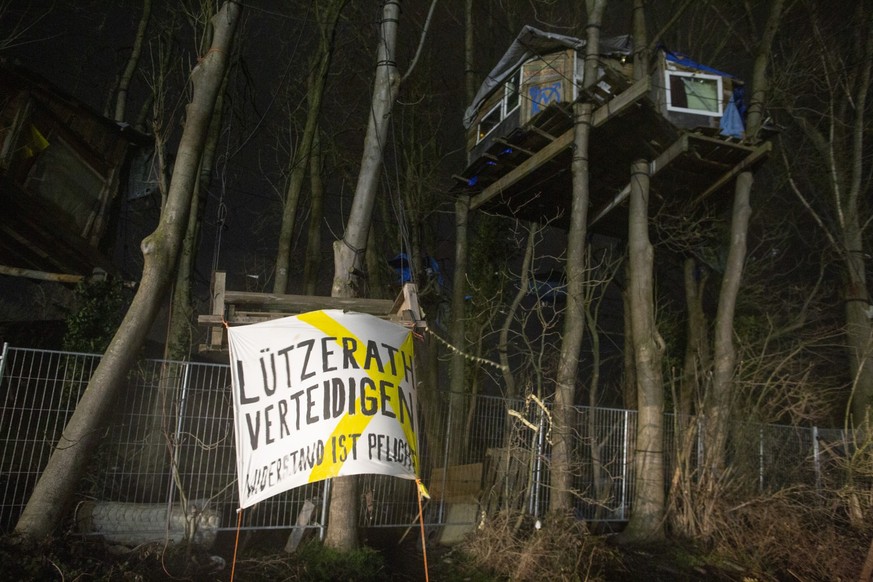 11.01.2023, Nordrhein-Westfalen, Erkelenz: Ein Banner mit der Aufschrift: &quot;Lützerath Verteidigen&quot; hängt vor einem Baumhaus. Der Energiekonzern RWE will die unter Lützerath liegende Kohle abb ...