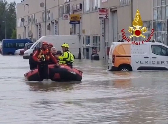 HANDOUT - 19.05.2023, Italien, Ravenna: Das Standbild aus einem Video zeigt Einsatzkräfte der Feuerwehr, die mit einem Schlauchboot Personen aus einem Hotel evakuieren. Nach den dramatischen Überschwe ...