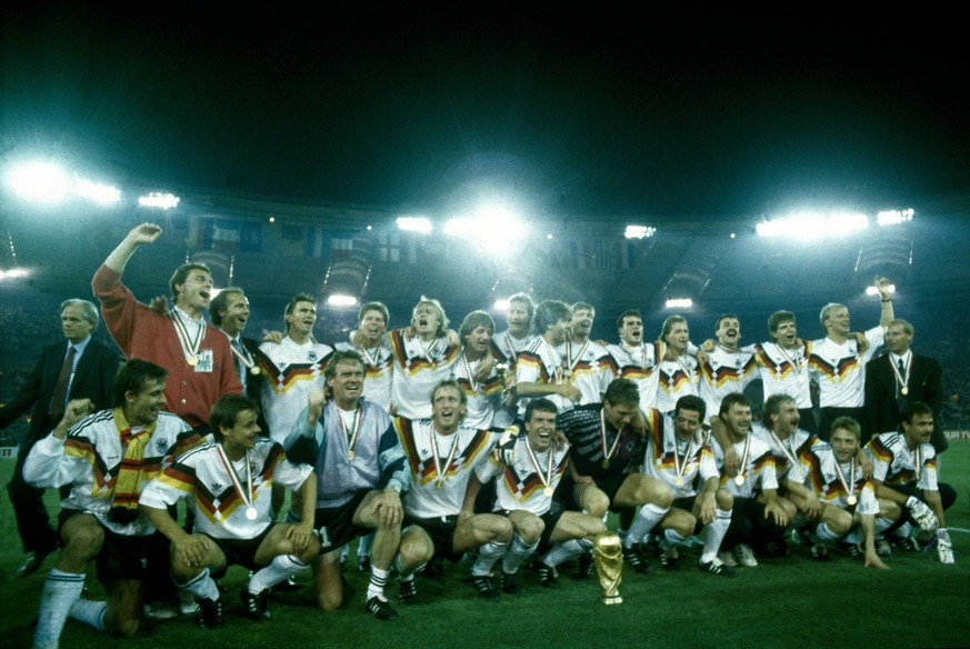 Weltmeisterschaft 1990. Die Deutsche Mannschaft mit WM Pokal nach dem Sieg im Finale am 8.7. in Rom, hi.v.li.: Holger Osieck, Franz Beckenbauer, Klaus Augenthaler, Stefan Reuter, J