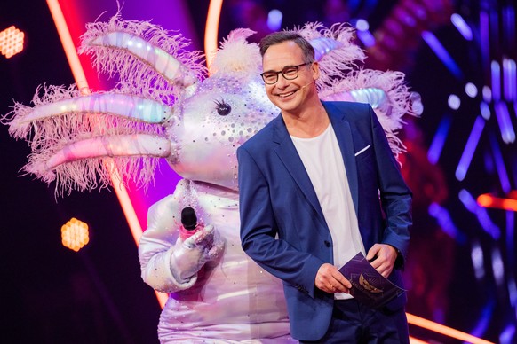 23.10.2021, Nordrhein-Westfalen, K�ln: Die Figur �Das Axolotl� steht in der Prosieben-Show �The Masked Singer� auf der B�hne neben Moderator Matthias Opdenh�vel. Foto: Rolf Vennenbernd/dpa +++ dpa-Bil ...