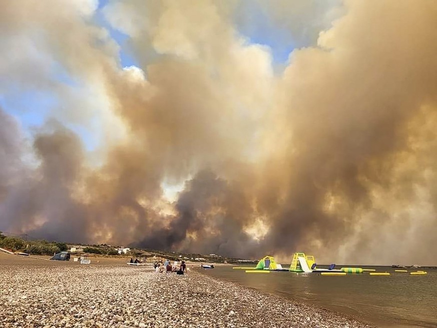 22.07.2023, Griechenland, Rhodos: Dichte Rauchwolken eines Waldbrandes steigen auf der griechischen Insel Rhodos in den Himmel. Ein Großbrand auf der griechischen Insel Rhodos, der bereits den fünften ...