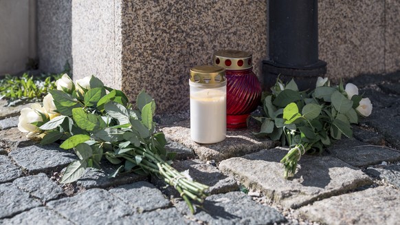 06.04.2023, Bayern, Wunsiedel: An der Straßenecke zur Zufahrtsstraße zum Kinder- und Jugendhilfezentrum, in dem eine Zehnjährige tot aufgefunden wurde, liegen Blumen und Grablichter auf dem Gehweg. Fo ...