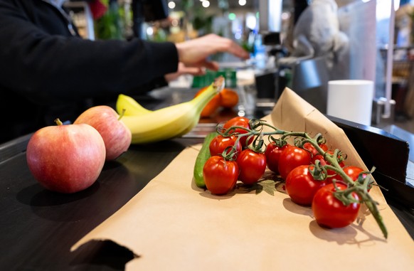 ARCHIV - 18.01.2023, Bayern, Neubiberg: Lebensmittel liegen in einem Supermarkt an der Kasse auf dem Band. Vorl�ufige Zahlen zum Bruttoinlandsprodukt (BIP) im vierten Quartal ver�ffentlicht die Wiesba ...