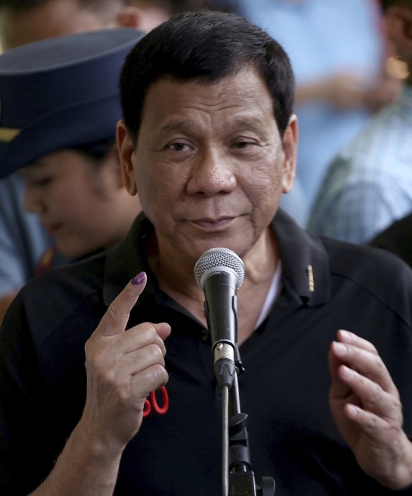 President Rodrigo Duterte shows his forefinger with an indelible ink to prove that he has voted for the country&#039;s midterm elections in his hometown of Davao city in southern Philippines Monday, M ...