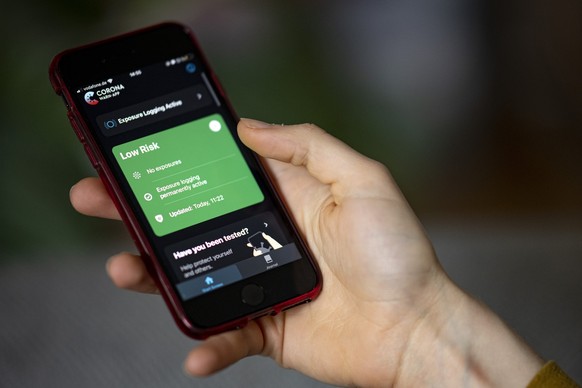 ARCHIV - 24.04.2021, Nordrhein-Westfalen, Berlin: Eine Person bedient mit ihrem Smartphone die Corona-Warn App. (zu dpa �Haus der Geschichte beleuchtet Digitalisierung in Deutschland �) Foto: Fabian S ...