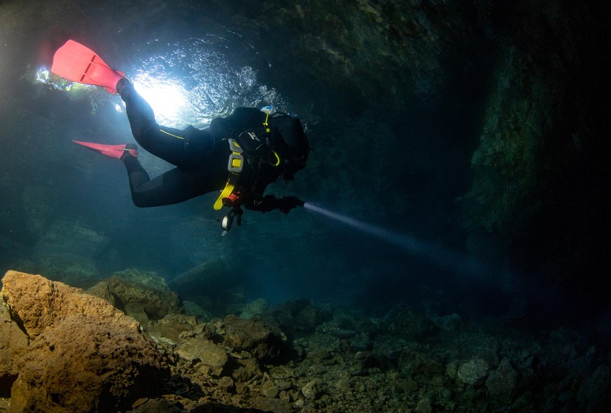 AYDIN, TURKIYE - JUNE 05: A diver holds a flashlight at the Cave of Zeus in Kusadasi district of Aydin, Turkiye on June 05, 2022. The cave was formed as a result of a sinkhole eroding a kalk formation ...