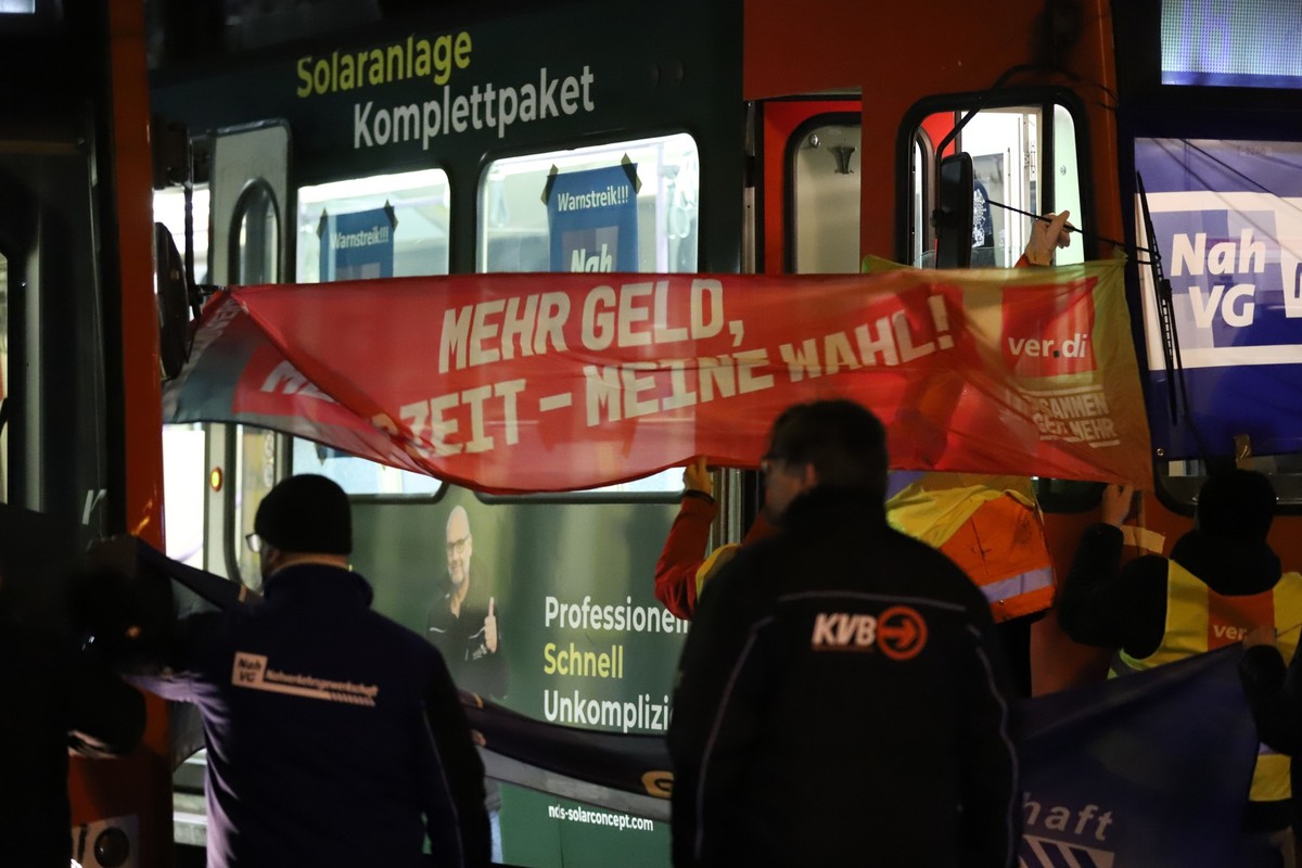 07.02.2025, Nordrhein-Westfalen, Köln: Streikende hängen ein Banner an einer Bahn auf. Die Dienstleistungsgewerkschaft Verdi hat zu einem Streik im öffentlichen Nahverkehr aufgerufen. Foto: Sascha The ...