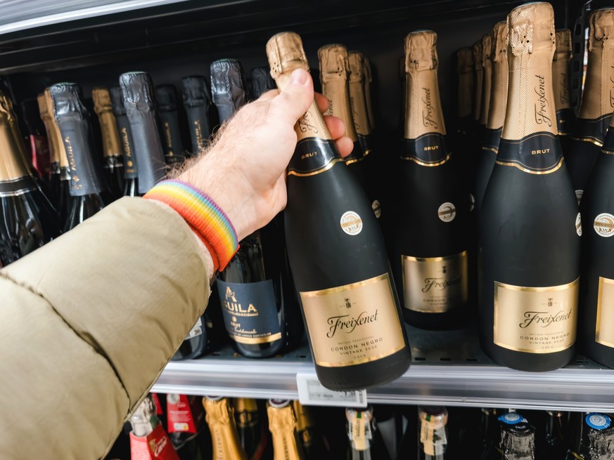 Paris, France - Nov 10, 2023: A POV perspective captures a customer reaching for a bottle of Freixenet champagne from the shelves, preparing for an upcoming holiday anniversary and special occasion