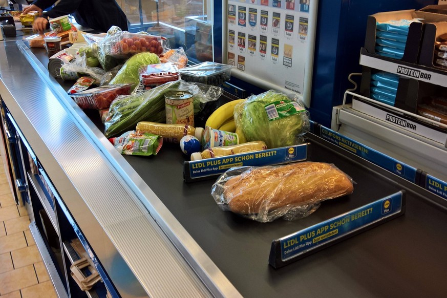 Lidl Supermarkt, Lebensmittel-Discounter, Kasse. Volles Kassenband nach dem Einkauf. Kunden, die nur ein Produkt oder wenige Artikel kaufen, werden heutzutage nur noch selten vorgelassen. Was frueher  ...