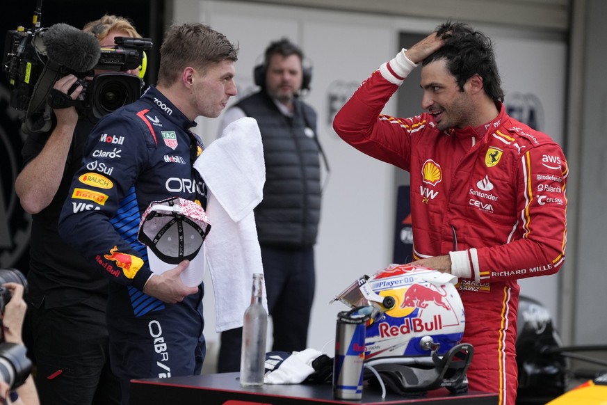 Red Bull driver Max Verstappen of the Netherlands, left, Ferrari driver Carlos Sainz of Spain, right, speak after the Japanese Formula One Grand Prix at the Suzuka Circuit in Suzuka, central Japan, Su ...
