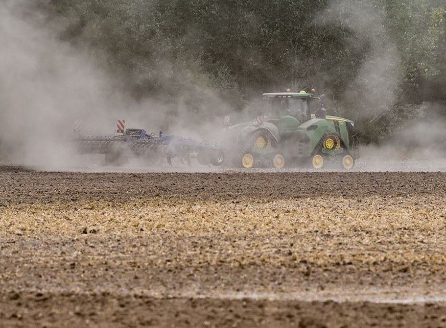 ARCHIV - 13.08.2022, Brandenburg, Manschnow: Ein Landwirt fährt mit einem Traktor und einer Egge über den trocken Ackerboden im Oderbruch in Ostbrandenburg. (zu dpa: «Kein Acker ohne Baum? Landwirte w ...