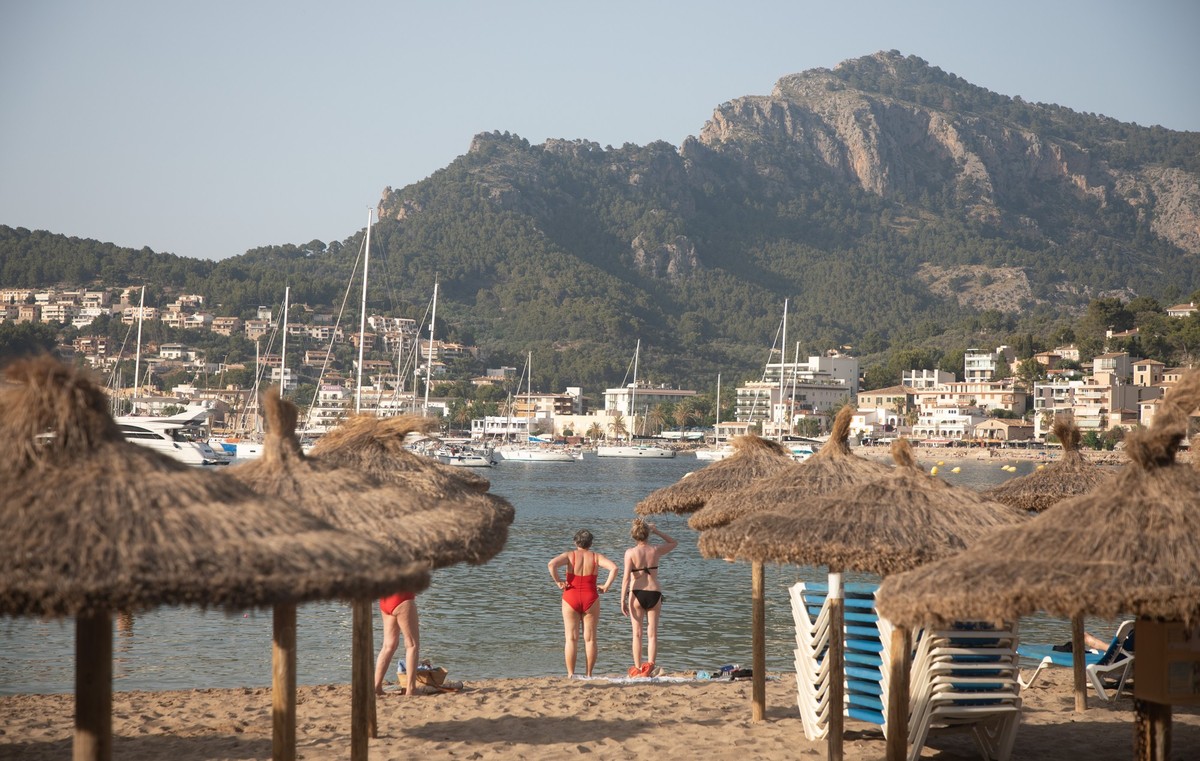 14.06.2025, Spanien, Soller: Menschen sonnen sich und schwimmen am Strand von Port de Soller auf Mallorca während einer Hitzewelle mit Temperaturen um 39 Grad am Wochenende auf den Balearen. Foto: Cla ...