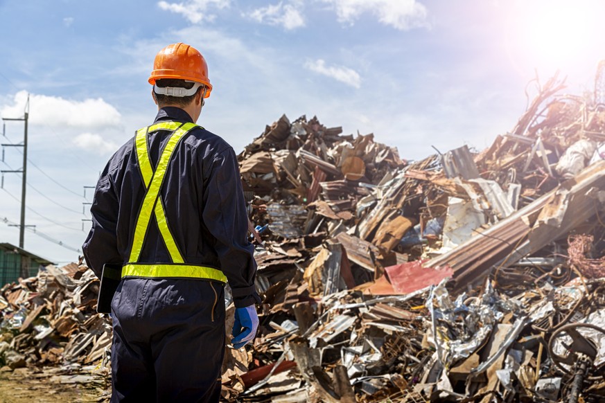 The engineers in the recycling plant that are carrying the tablet. Looking for recycled materials with paper, metal, glass laid in the factory.