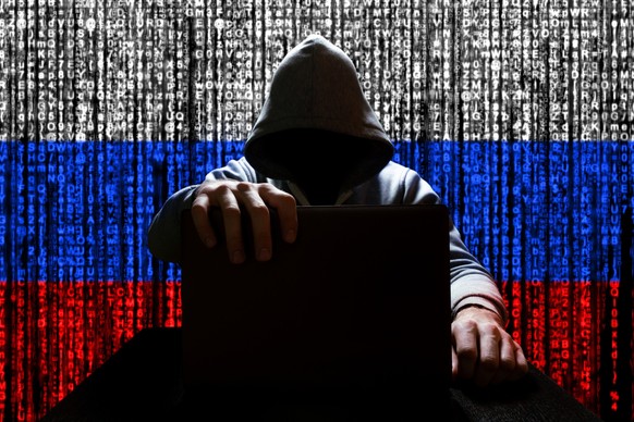 Russian hacker closes the lid of the laptop, against the backdrop of a binary code, the color of the Russian tricolor