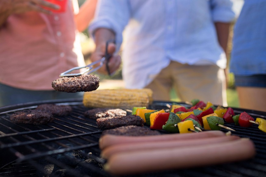 Family grilling patties, vegetables and sausages on the barbecue grill Copyright: xWavebreakmediaMicrox Panthermedia23058317,model released, Symbolfoto