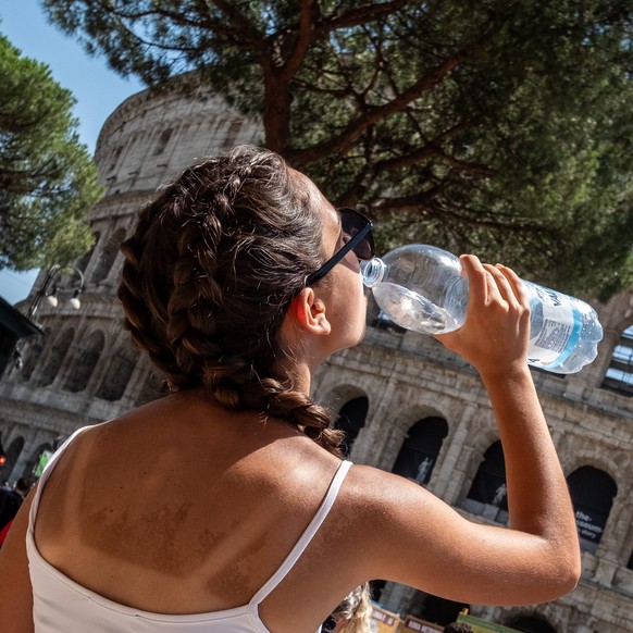 Eine junge Touristin erfrischt sich in der Nähe des Kolosseums in Rom von der Hitze (Symbolbild).