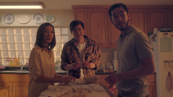 This image released by Netflix shows Michelle Yeoh as Mama Sun, Sam Song Li as Bruce Sun, and Justin Chien as Charles Sun in an episode of &quot;The Brothers Sun.&quot; (Netflix via AP)