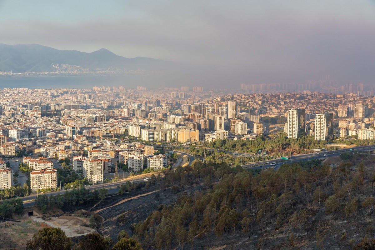 17.08.2024, Türkei, Izmir: Übersicht über die Bezirke Bayrakli und Karsiyaka nach dem Brand, während die Lösch- und Kühlungsarbeiten am zweiten Tag des großen Izmir-Brandes fortgesetzt werden. Der Wal ...
