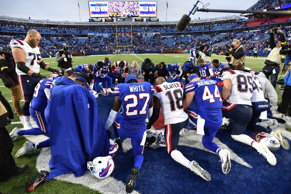 08.01.2023, USA, Orchard Park: American Football: Profiliga NFL, Buffalo Bills - New England Patriots: Spieler beider Mannschaften versammeln sich nach dem Spiel zu einem Gebet. Damar Hamlin von den B ...