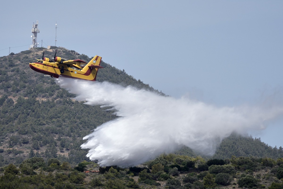 ARCHIV - 22.05.2025, Griechenland, Athen: Ein Feuerwehrflugzeug wirft während einer Übung Wasser über einem Wald in Lavrio, etwa 60 Kilometer südöstlich von Athen, ab. (zu dpa: «Großer Brand im Südost ...