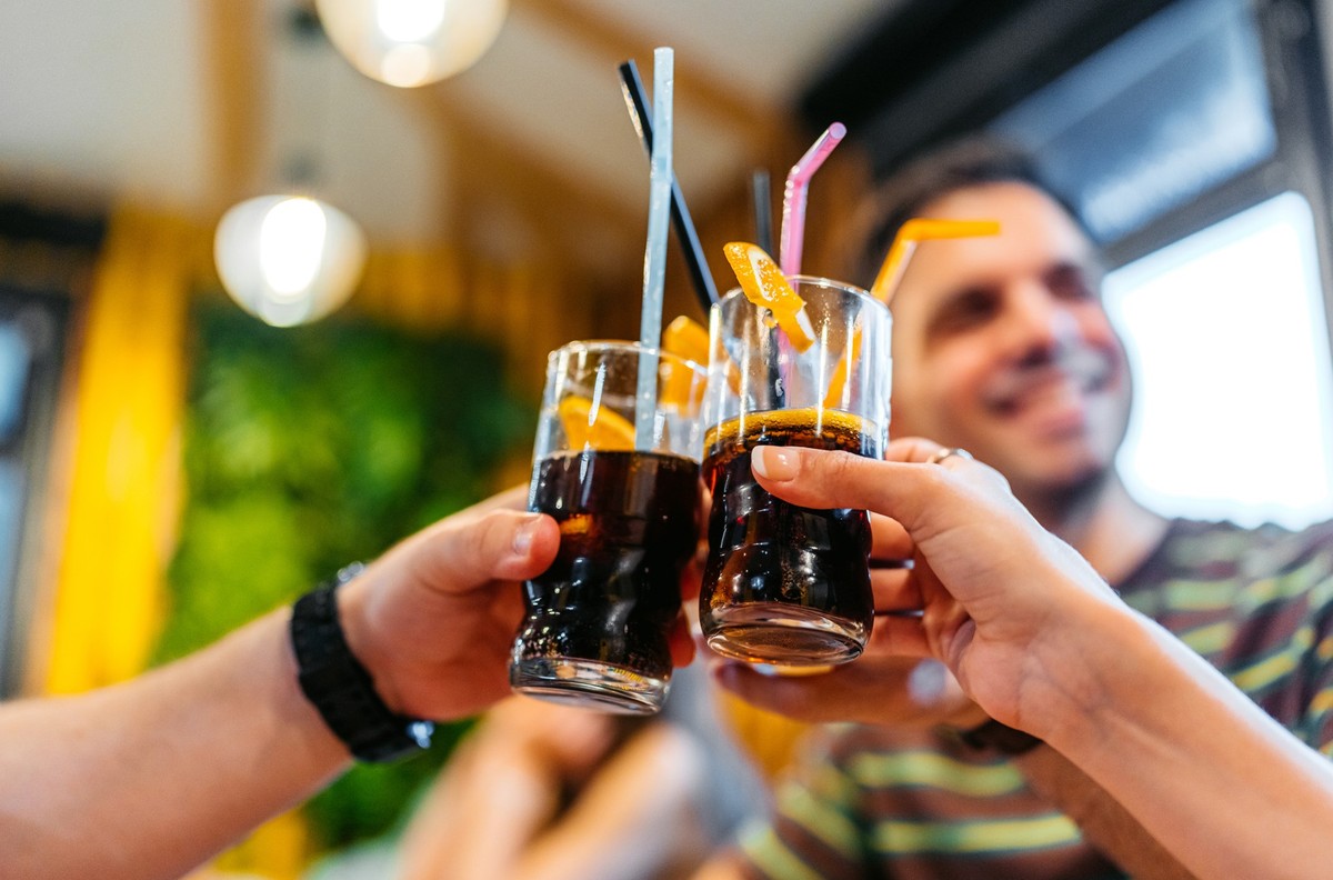 Young group of friends relaxing in a café,cheering with their drinks indoors.