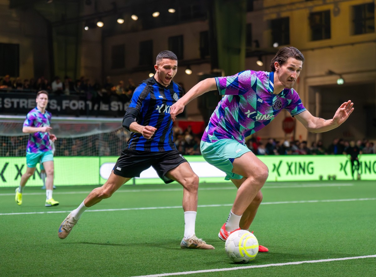 31.03.2025, Berlin: Fußball: 5. Spieltag der Baller League im Hangar 7 des ehemaligen Flughafens Tempelhof, FC Nitro - Streets United. Max Düwel (r) von Streets United gegen Malek Amdouni von FC Nitro ...