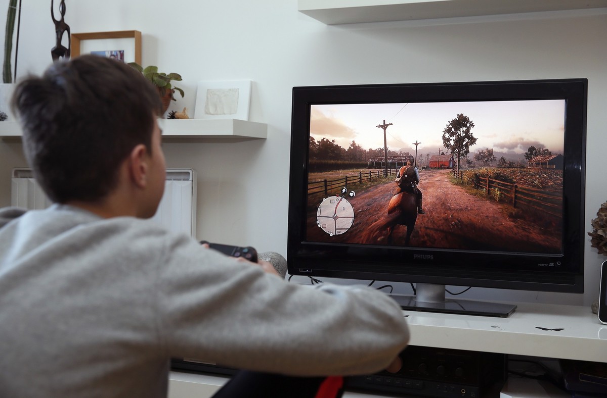 PARIS, FRANCE - JANUARY 09: In this photo illustration a gamer plays the video game 'Red Dead Redemption 2' (RDR 2) on January 9, 2019 in Paris, France. Red Dead Redemption 2, typographed Re ...