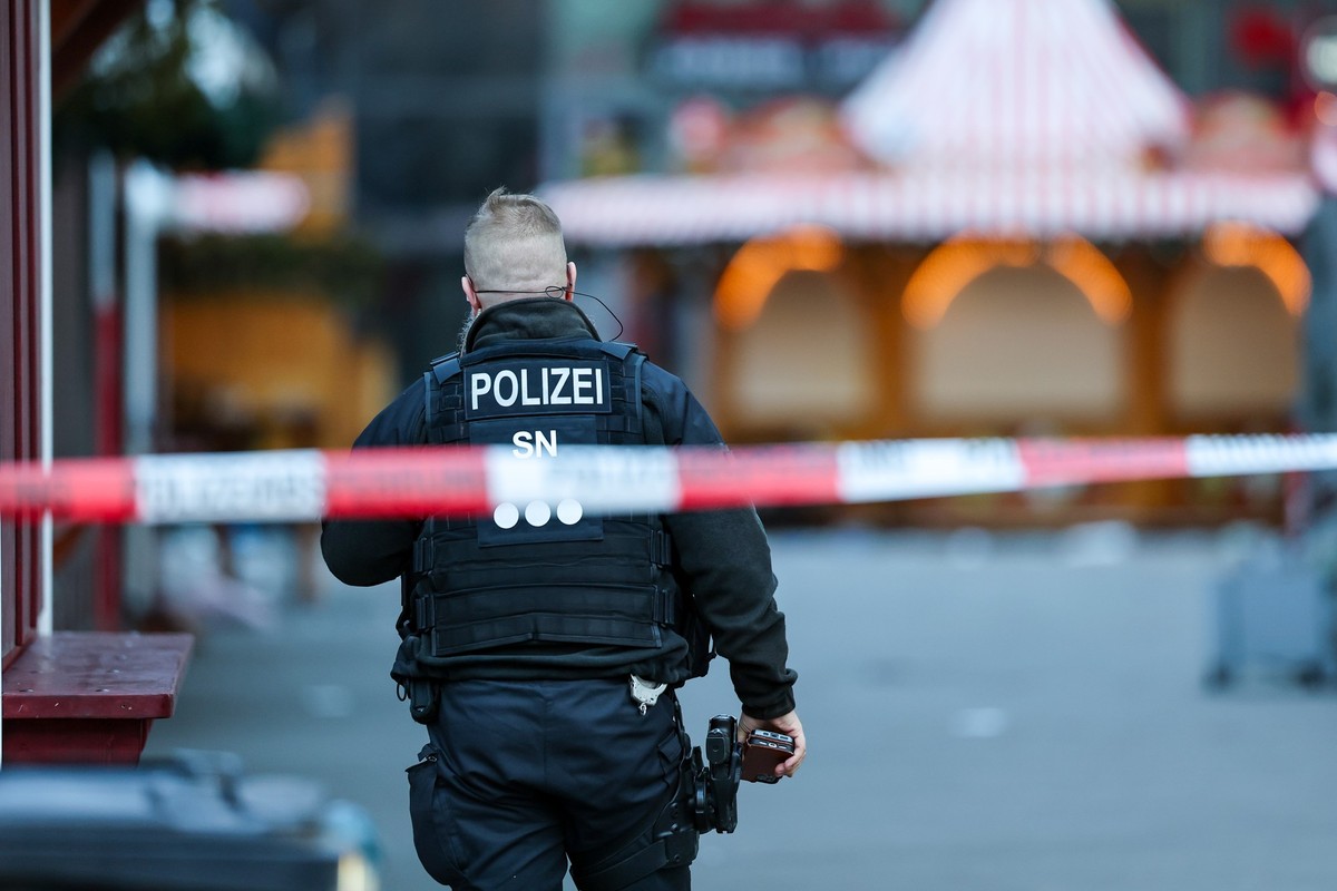21.12.2024, Sachsen-Anhalt, Magdeburg: Ein Polizist steht hinter einer Absperrung am Magdeburger Weihnachtsmarkt. Am Vorabend war ein Autofahrer in eine Menschengruppe gefahren. Es gab mehrere Tote un ...