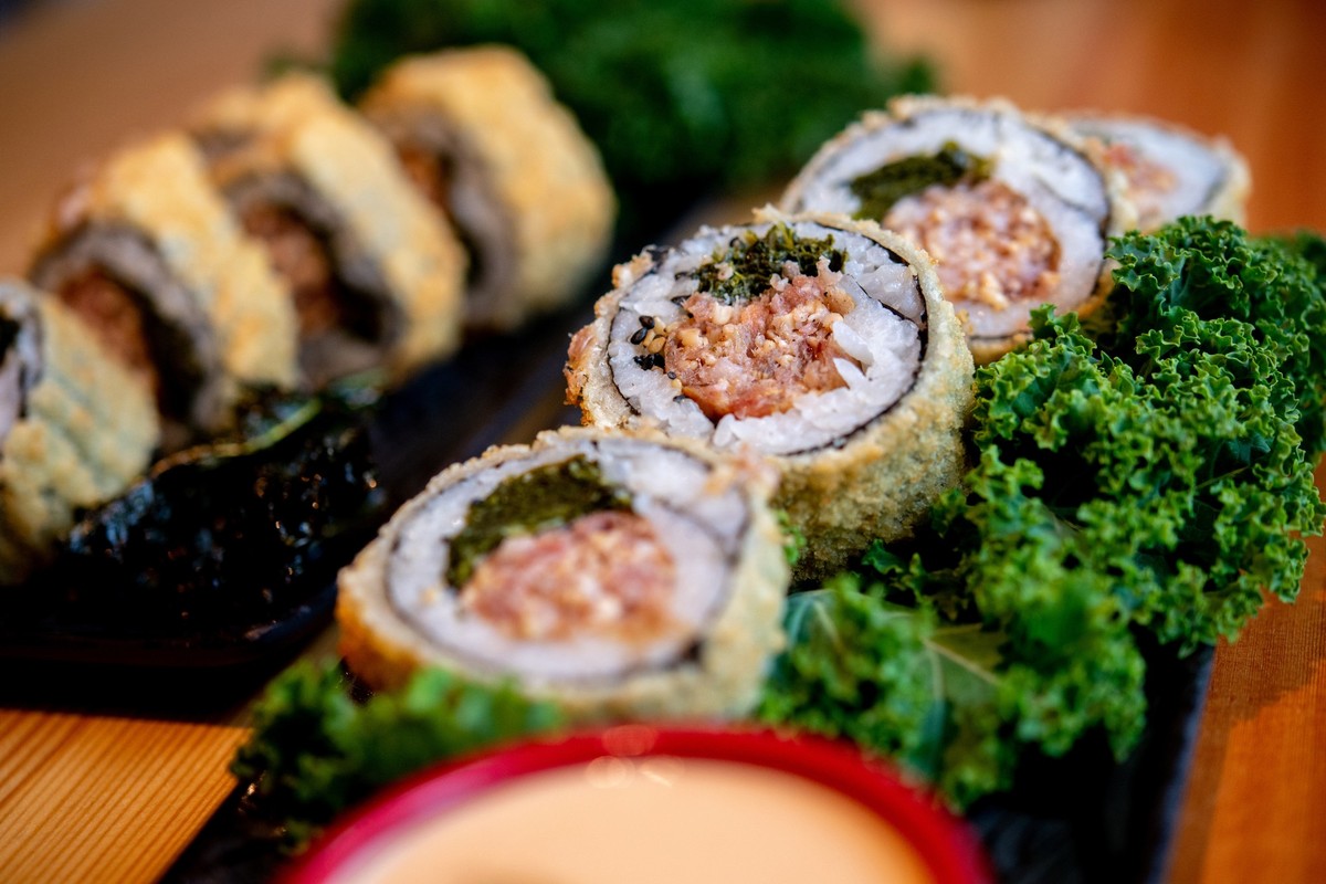PRODUKTION - 07.11.2023, Niedersachsen, Oldenburg: Sushi mit Grünkohl und Pinkel steht im Restaurant Moto Kitchen auf einem Tisch. Das Restaurant in Oldenburg bietet mit &quot;Crunchy Pinkel&quot; ers ...