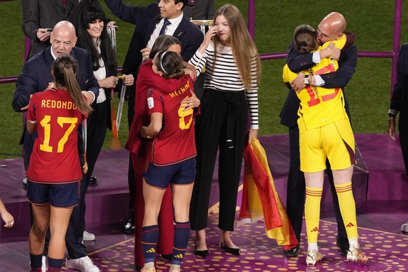 President of Spain&#039;s soccer federation, Luis Rubiales, right, embraces reserve goalkeeper Enith Salon on the podium following Spain&#039;s win in the final of Women&#039;s World Cup soccer agains ...