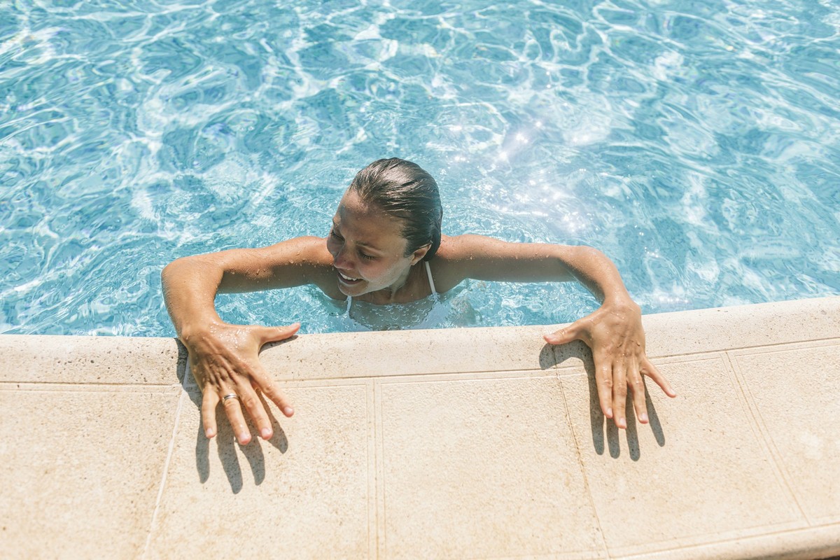 Happy woman coming out of swimming pool on sunny day model released, Symbolfoto, SIF01193