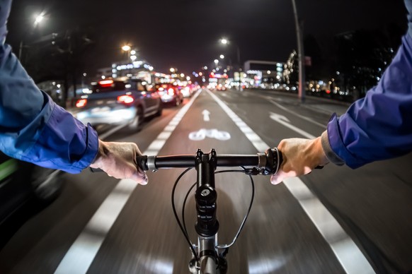 Cyclist drives on the bike path past the traffic jam. - First-person view of cyclist