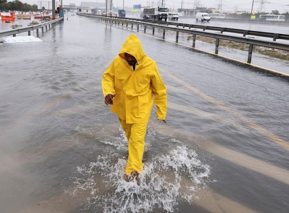A worker walks through floods caused by heavy rains in Dubai, United Arab Emirates, March 9, 2024. REUTERS/Amr Alfiky