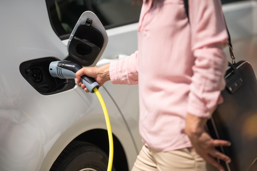 Woman charging electric car