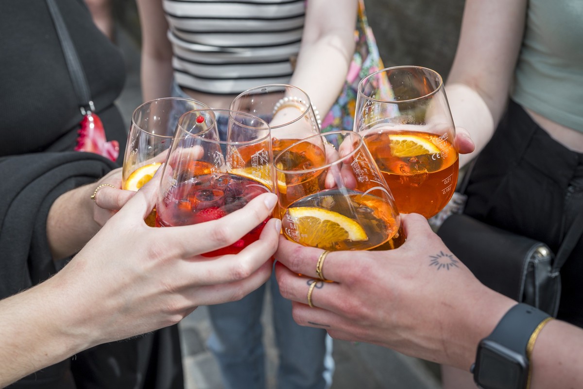 01.05.2024, Bayern, Bamberg: Fünf Personen stoßen mit ihren Gläsern mit Aperol Spritz an. Foto: Daniel Vogl/dpa +++ dpa-Bildfunk +++