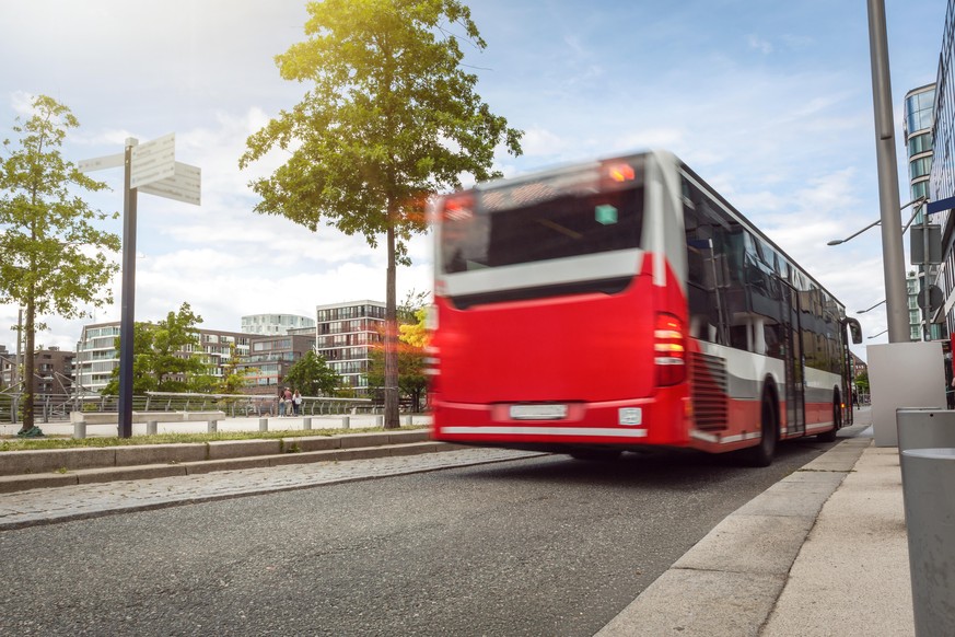 Rear view of a slightly motion blurred bus driving on a street in Germany.