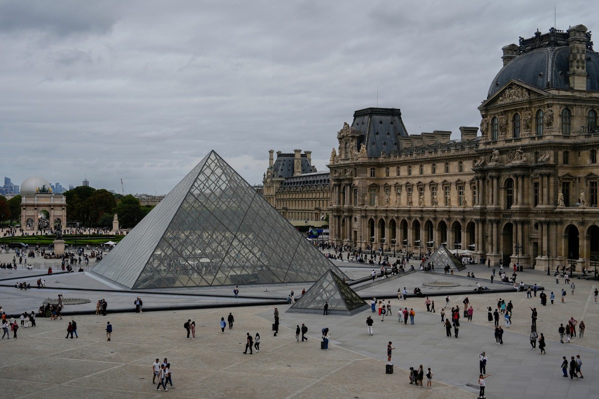 People walk outside the Louvre museum, Sunday, Aug. 31, 2025, in Paris. (AP Photo/Julia Demaree Nikhinson)