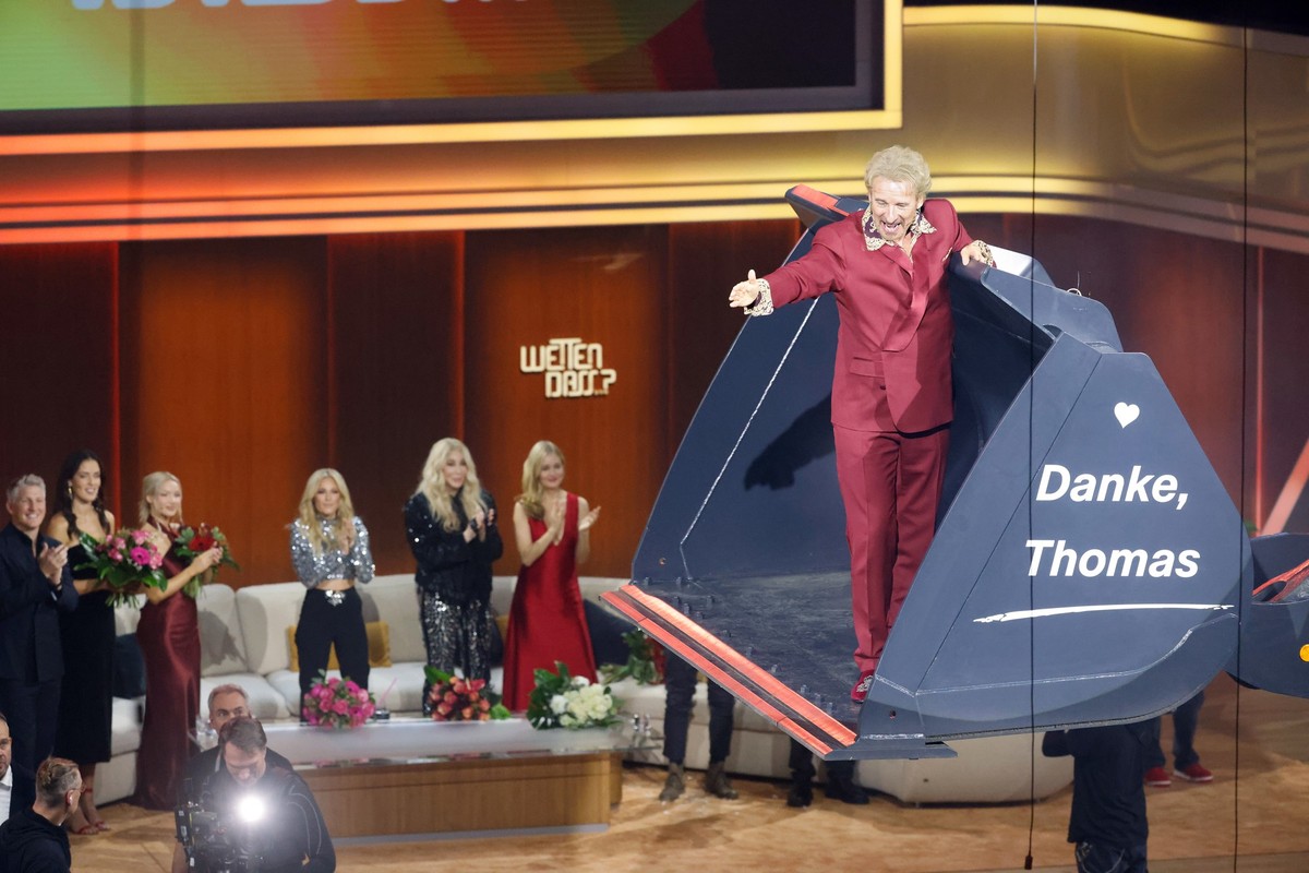 ARCHIV - 25.11.2023, Baden-Württemberg, Offenburg: Moderator Thomas Gottschalk wird am Ende der ZDF-Show &quot;Wetten, dass..?&quot; in einer Baggerschaufel über die Bühne gefahren. Gottschalk moderie ...