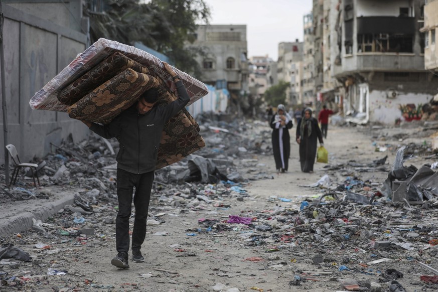 25.11.2023, Palästinensische Gebiete, Shati: Palästinenser gehen am zweiten Tag der vorübergehenden Waffenruhe zwischen der Hamas und Israel durch das Flüchtlingslager Shati. Foto: Mohammed Hajjar/AP/ ...