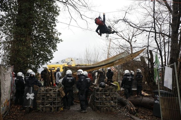 Ein Aktivist hängt zwischen den Bäumen in den Seilen, um der Polizei den Zugriff zu erschweren.