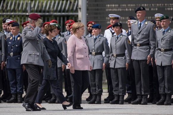 Sie muss das nicht alleine tun, sondern hat zu ihrer Linken die Kanzlerin, rechts von ihr marschiert der oberste General der Bundeswehr, Eberhard Zorn.