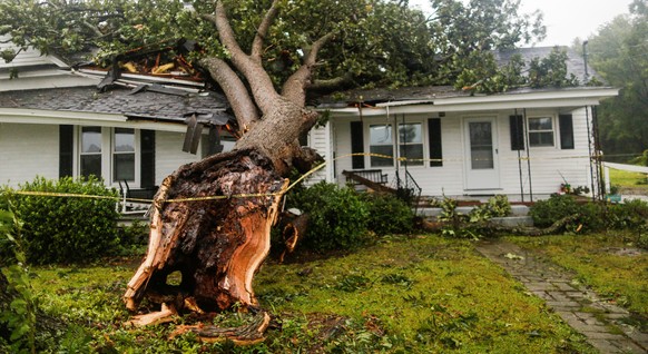 A downed tree rests on a house during the passing of Hurricane Florence in the town of Wilson, North Carolina, U.S. September 14, 2018. REUTERS/Eduardo Munoz