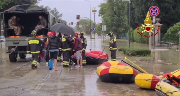 HANDOUT - 17.05.2023, Italien, ---: Das Standbild aus einem Video zeigt Feuerwehrleute mit Schlauchbooten und Soldaten, die Anwohner in dem von �berschwemmungen betroffenen Gebiet versorgen. Die itali ...