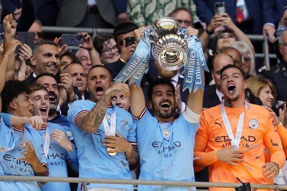 Manchester City&#039;s Ilkay Gundogan raises the trophy after his team won the English FA Cup final soccer match between Manchester City and Manchester United at Wembley Stadium in London, Saturday, J ...