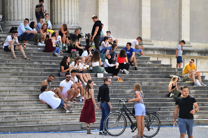 Oeffentliches Leben im Corona Sommer 2020 am 29.07. Personen,Menschen sitzen teilweise dichtgedraengt und ohne Mundschutz,Maske auf einer Treppe auf dem Koenigsplatz in Muenchen im Freien. *** Public  ...