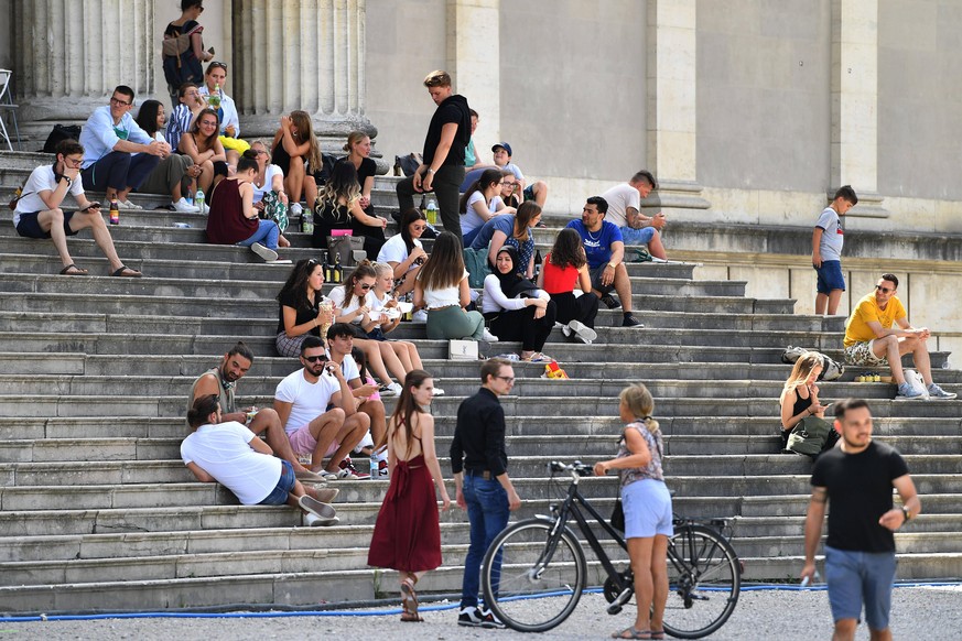 Oeffentliches Leben im Corona Sommer 2020 am 29.07. Personen,Menschen sitzen teilweise dichtgedraengt und ohne Mundschutz,Maske auf einer Treppe auf dem Koenigsplatz in Muenchen im Freien. *** Public ...